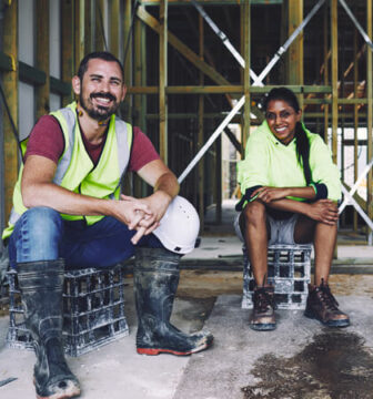 A man and a teenage girl sit at a construction site